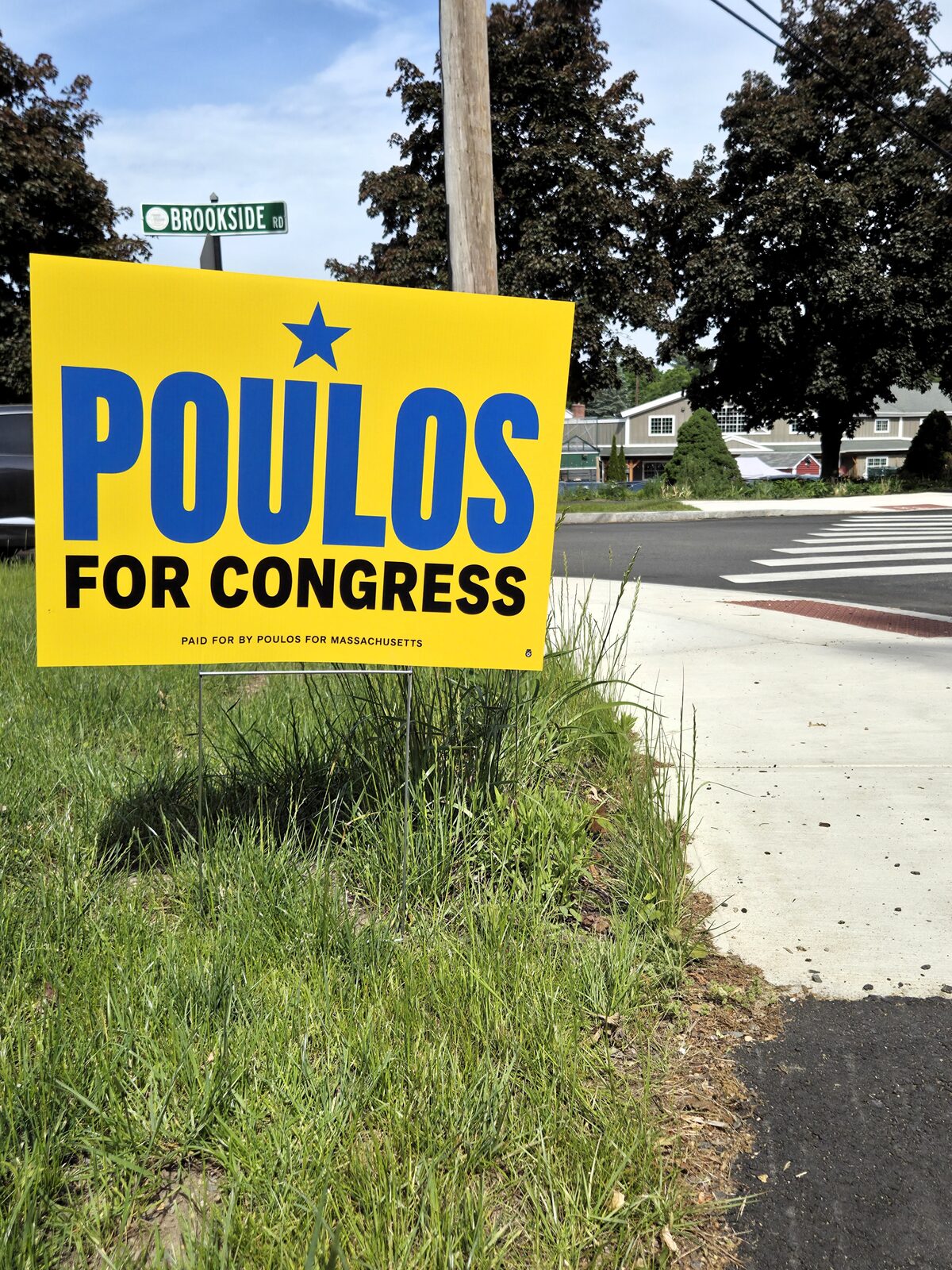 A Jason Poulos for Congress lawn sign displayed in a yard in MA-04
