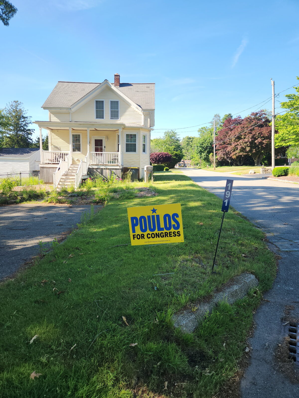A Poulos for Congress lawn sign posted along a neighborhood street in MA-04